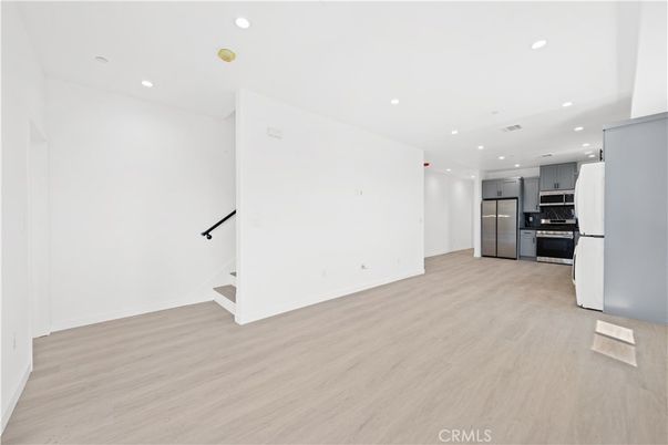 Empty room, Interior, Kitchen, Recessed Lighting, Stainless Steel Appliances, Wood Texture Flooring