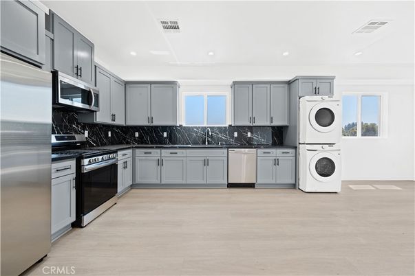 Interior, Kitchen, Marble Walls, Recessed Lighting, Stainless Steel Appliances, Washer, Wood Texture Flooring