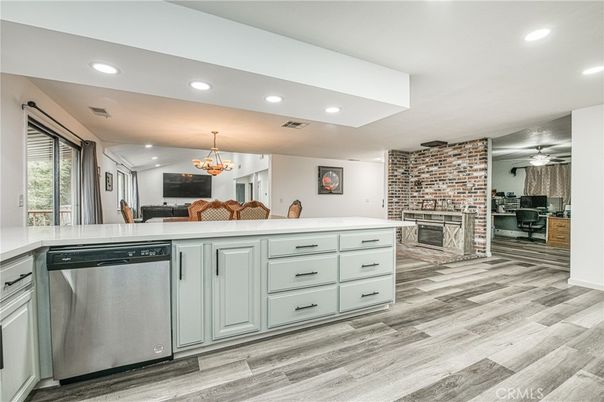Chandelier, Dining room, Fireplace, Interior, Kitchen, Recessed Lighting, Stainless Steel Appliances, Stone Walls, Wood Texture Flooring