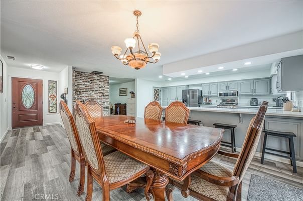 Chandelier, Dining room, Interior, Kitchen, Recessed Lighting, Stainless Steel Appliances, Stone Walls, Wood Texture Flooring