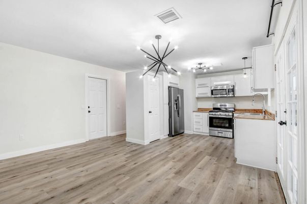 Empty room, Interior, Kitchen, Pendant Lights, Stainless Steel Appliances, Wood Texture Flooring