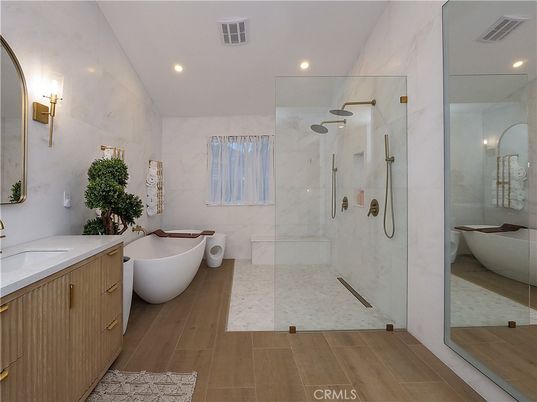 Bathroom, Dual Sink Vanities, Free Standing Baths, Glass Shower, Interior, Marble Walls, Recessed Lighting, Wood Texture Flooring