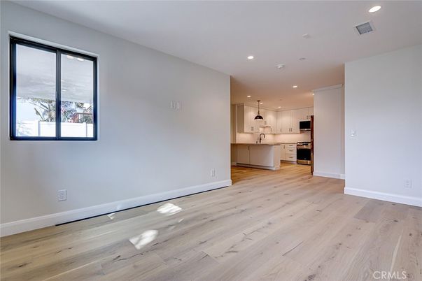 Empty room, Interior, Kitchen, Pendant Lights, Recessed Lighting, Stainless Steel Appliances, Wood Texture Flooring
