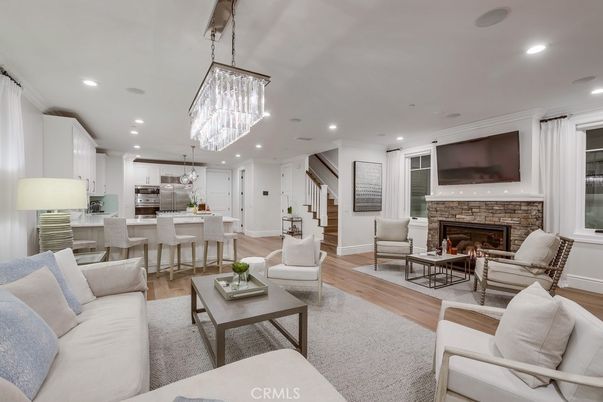 Chandelier, Fireplace, Interior, Kitchen, Living room, Pendant Lights, Recessed Lighting, Stainless Steel Appliances, Wood Texture Flooring