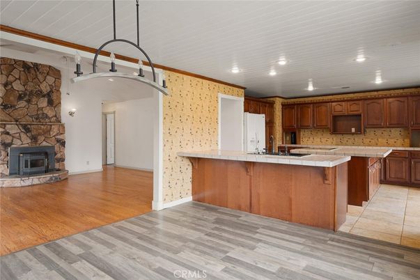 Fireplace, Interior, Kitchen, Recessed Lighting, Stone Walls, Tile Countertops, Wood Texture Flooring