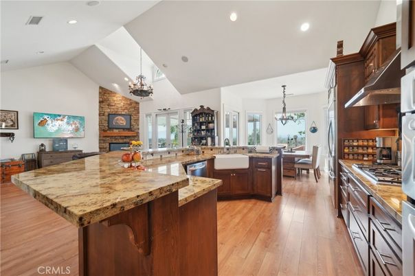 Chandelier, Dining room, Fireplace, Interior, Kitchen, Pendant Lights, Recessed Lighting, Stainless Steel Appliances, Stone Walls, Wood Texture Flooring