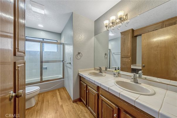 Bathroom, Dual Sink Vanities, Glass Shower, Interior, Recessed Lighting, Tile Countertops, Wood Texture Flooring