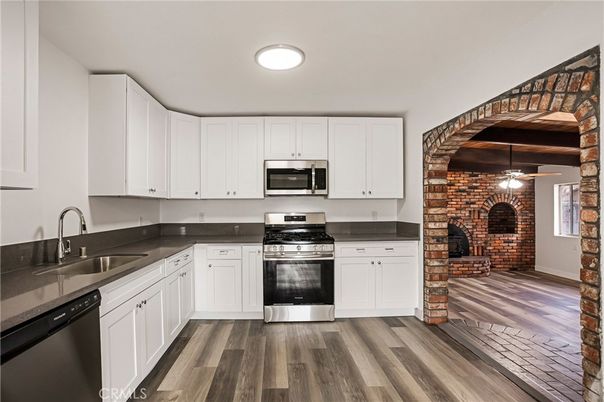 Fireplace, Interior, Kitchen, Recessed Lighting, Stainless Steel Appliances, Stone Walls, Washer, Wood Texture Flooring