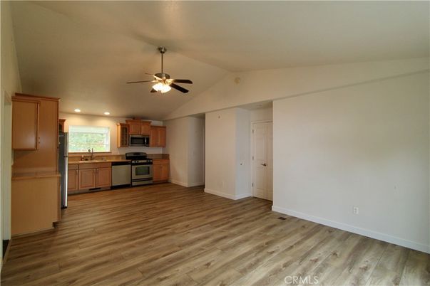 Empty room, Interior, Kitchen, Recessed Lighting, Stainless Steel Appliances, Wood Texture Flooring