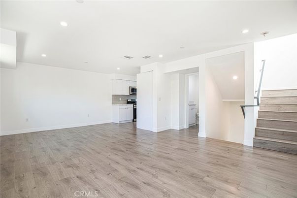Empty room, Interior, Kitchen, Recessed Lighting, Stainless Steel Appliances, Wood Texture Flooring