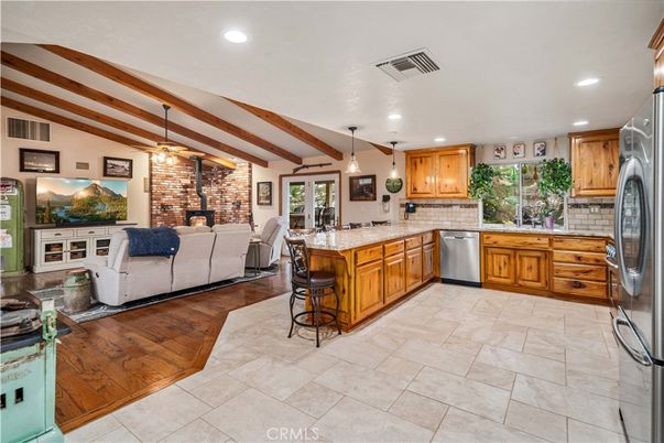 Fireplace, Interior, Kitchen, Living room, Pendant Lights, Recessed Lighting, Stainless Steel Appliances, Stone Walls, Wooden Beams, Wood Texture Flooring