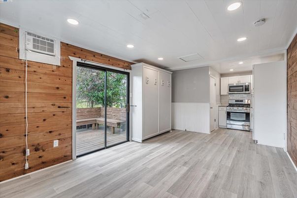 Empty room, Interior, Kitchen, Recessed Lighting, Stainless Steel Appliances, Wood Texture Flooring, Wooden Walls