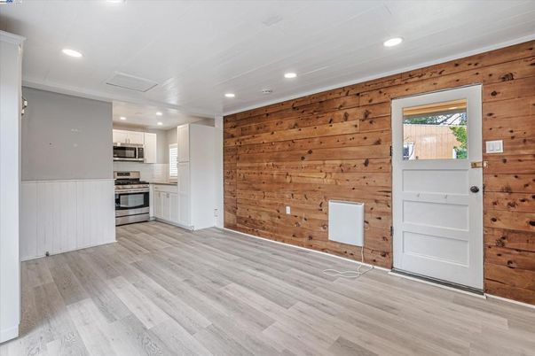 Empty room, Interior, Kitchen, Recessed Lighting, Stainless Steel Appliances, Wood Texture Flooring, Wooden Walls