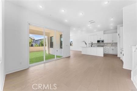 Empty room, Interior, Kitchen, Recessed Lighting, Stainless Steel Appliances, Wood Texture Flooring