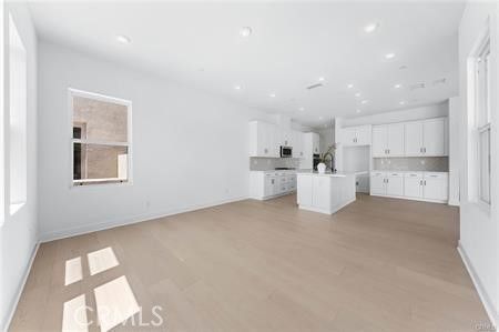 Empty room, Interior, Kitchen, Recessed Lighting, Stainless Steel Appliances, Wood Texture Flooring