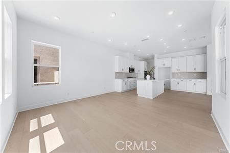 Empty room, Interior, Kitchen, Recessed Lighting, Stainless Steel Appliances, Wood Texture Flooring