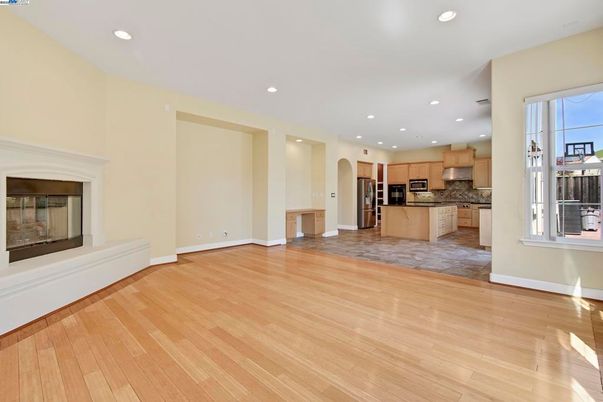 Empty room, Fireplace, Interior, Kitchen, Recessed Lighting, Stainless Steel Appliances, Wood Texture Flooring