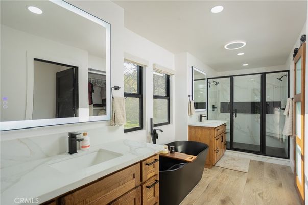 Bathroom, Dual Sink Vanities, Glass Shower, Interior, Marble Walls, Recessed Lighting, Wood Texture Flooring