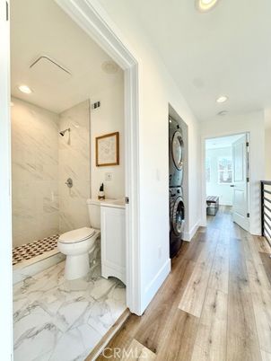 Bathroom, Glass Shower, Interior, Marble, Marble Walls, Recessed Lighting, Washer, Wood Texture Flooring