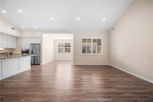 Empty room, Interior, Kitchen, Recessed Lighting, Stainless Steel Appliances, Wood Texture Flooring