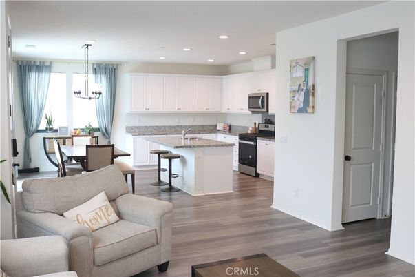 Chandelier, Dining room, Interior, Kitchen, Living room, Pendant Lights, Recessed Lighting, Stainless Steel Appliances, Wood Texture Flooring
