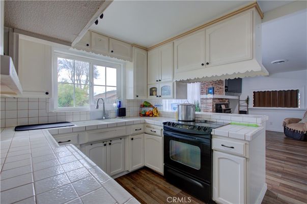 Fireplace, Interior, Kitchen, Stone Walls, Tile Countertops, Wood Texture Flooring