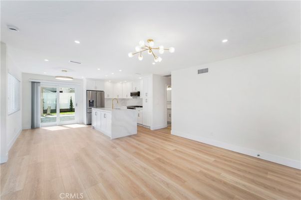 Empty room, Interior, Kitchen, Pendant Lights, Recessed Lighting, Stainless Steel Appliances, Wood Texture Flooring