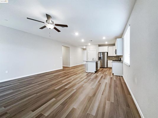 Empty room, Interior, Kitchen, Recessed Lighting, Stainless Steel Appliances, Wood Texture Flooring