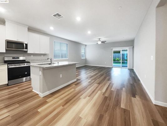 Empty room, Interior, Kitchen, Recessed Lighting, Stainless Steel Appliances, Wood Texture Flooring