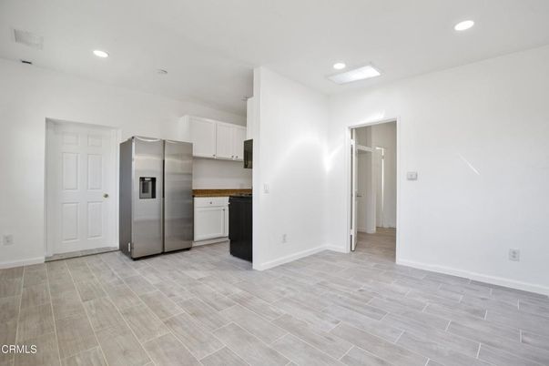 Empty room, Interior, Kitchen, Recessed Lighting, Stainless Steel Appliances, Wood Texture Flooring