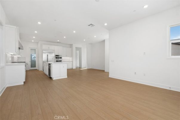 Empty room, Interior, Kitchen, Recessed Lighting, Stainless Steel Appliances, Wood Texture Flooring