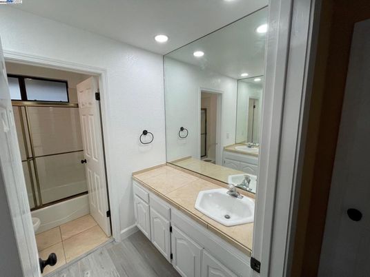 Bathroom, Dual Sink Vanities, Glass Shower, Interior, Recessed Lighting, Tile Countertops, Wood Texture Flooring