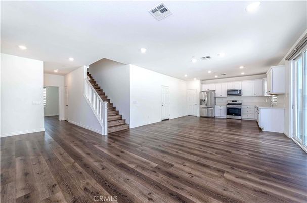 Empty room, Interior, Kitchen, Recessed Lighting, Stainless Steel Appliances, Wood Texture Flooring