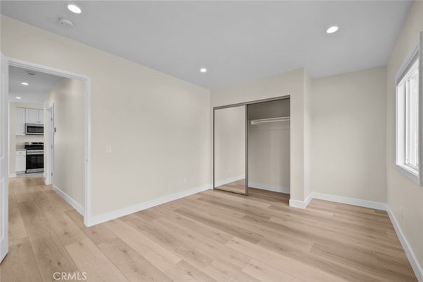 Empty room, Interior, Kitchen, Recessed Lighting, Stainless Steel Appliances, Wood Texture Flooring