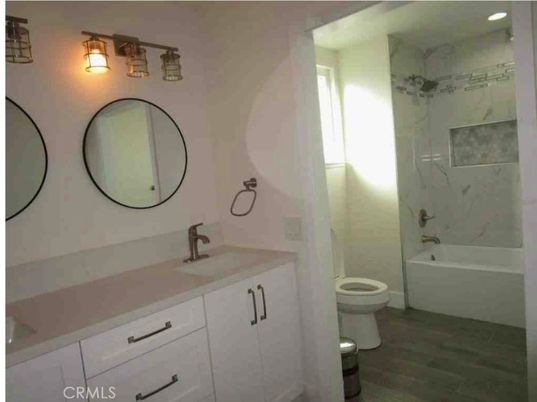 Bathroom, Dual Sink Vanities, Interior, Marble Walls, Recessed Lighting, Wood Texture Flooring