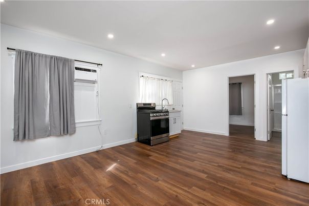 Empty room, Interior, Kitchen, Recessed Lighting, Stainless Steel Appliances, Wood Texture Flooring