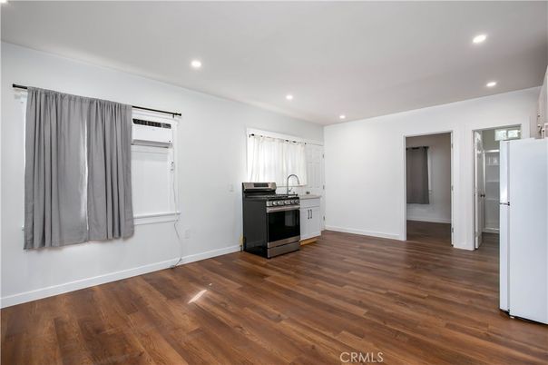 Empty room, Interior, Kitchen, Recessed Lighting, Stainless Steel Appliances, Wood Texture Flooring
