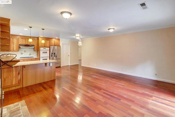 Empty room, Interior, Kitchen, Pendant Lights, Recessed Lighting, Stainless Steel Appliances, Wood Texture Flooring