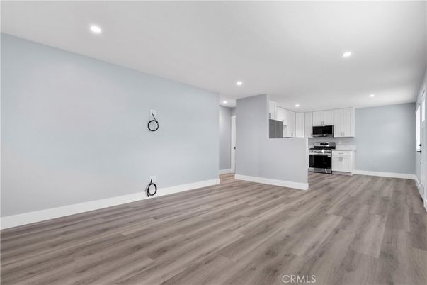 Empty room, Interior, Kitchen, Recessed Lighting, Stainless Steel Appliances, Wood Texture Flooring