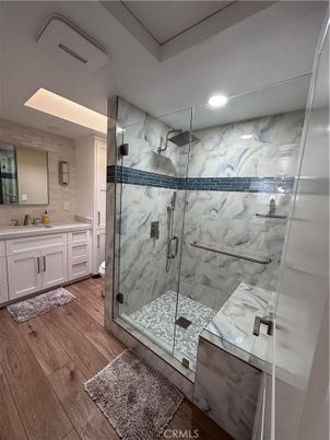 Bathroom, Dual Sink Vanities, Glass Shower, Interior, Marble Walls, Recessed Lighting, Wood Texture Flooring