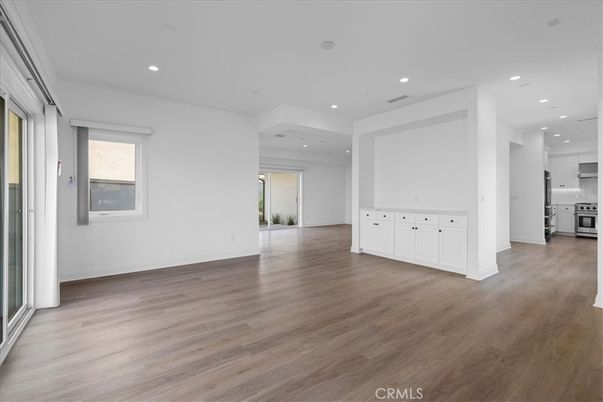 Empty room, Interior, Kitchen, Recessed Lighting, Stainless Steel Appliances, Wood Texture Flooring