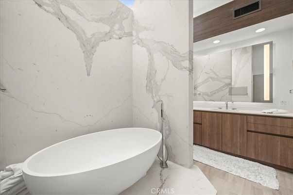 Bathroom, Dual Sink Vanities, Free Standing Baths, Interior, Marble, Marble Walls, Recessed Lighting, Wood Texture Flooring