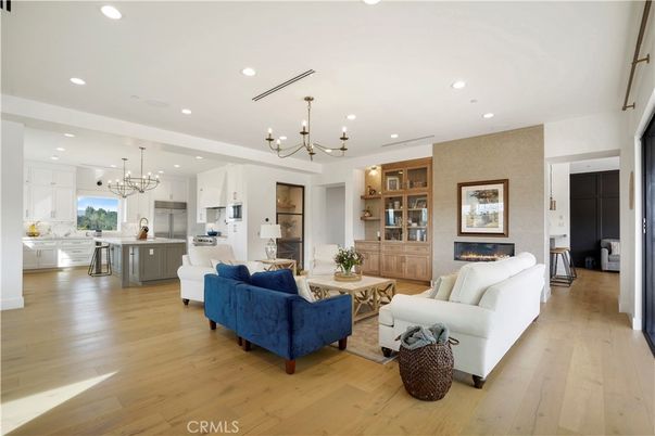 Chandelier, Fireplace, Interior, Kitchen, Living room, Pendant Lights, Recessed Lighting, Stainless Steel Appliances, Wood Texture Flooring