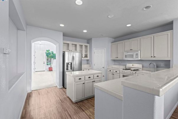 Interior, Kitchen, Recessed Lighting, Stainless Steel Appliances, Tile Countertops, Wood Texture Flooring