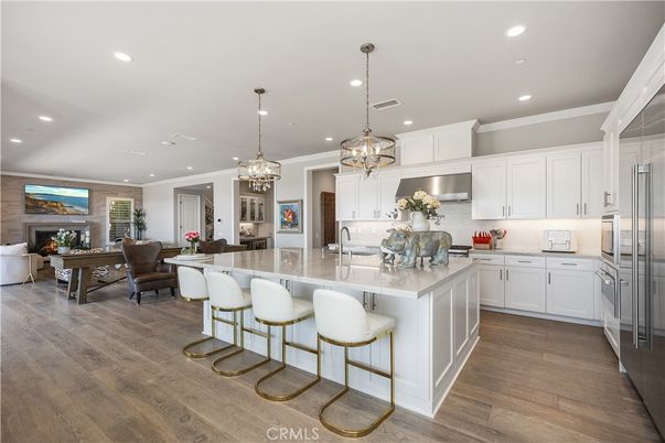 Chandelier, Dining room, Fireplace, Interior, Kitchen, Living room, Pendant Lights, Recessed Lighting, Stainless Steel Appliances, Wood Texture Flooring