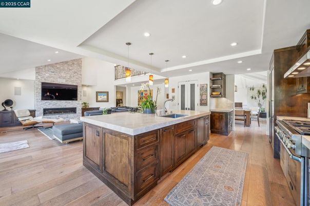 Fireplace, Interior, Kitchen, Living room, Pendant Lights, Recessed Lighting, Stainless Steel Appliances, Stone Walls, Wood Texture Flooring