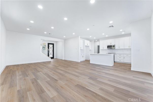 Empty room, Interior, Kitchen, Recessed Lighting, Stainless Steel Appliances, Wood Texture Flooring