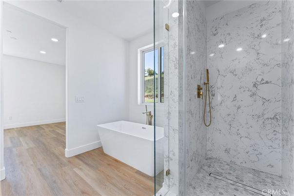 Bathroom, Free Standing Baths, Glass Shower, Interior, Marble Walls, Recessed Lighting, Wood Texture Flooring