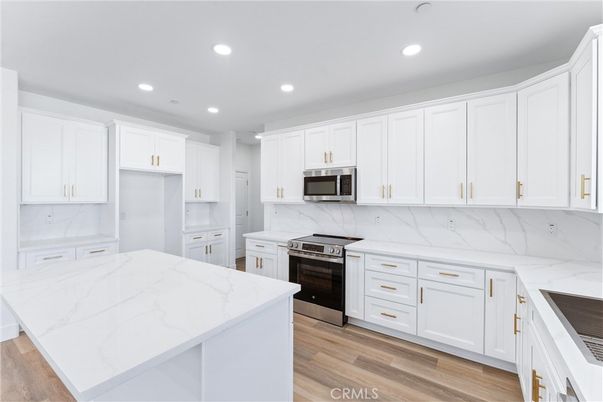 Interior, Kitchen, Marble Walls, Recessed Lighting, Stainless Steel Appliances, Wood Texture Flooring