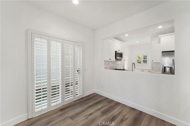 Empty room, Interior, Kitchen, Recessed Lighting, Stainless Steel Appliances, Wood Texture Flooring